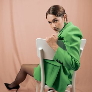 female model wearing a green jacket in a fashion photo shoot
